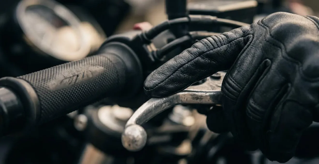Gros plan sur la main gauche d'un motard trouvant le point de patinage sur le levier d'embrayage