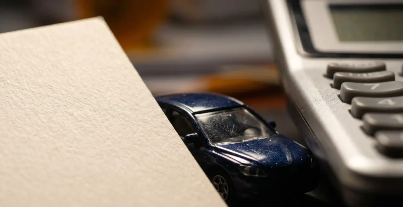 Gros plan sur un bureau avec calculatrice et modèle de voiture miniature